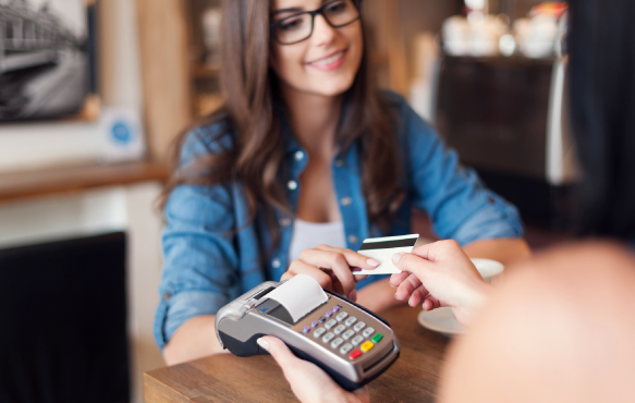 A woman using a debit/credit card for a payment